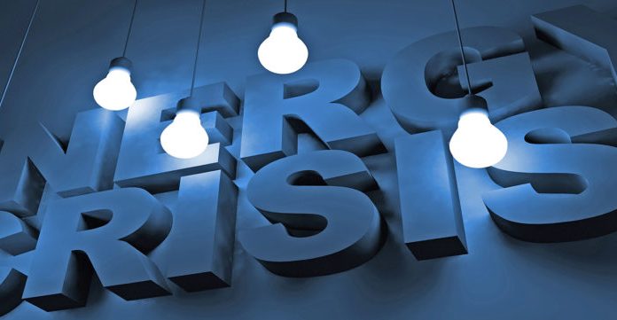 blue 3 D sign with lighting in front with the wording energy crisis