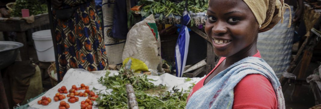 Black woman smiling in an informal market setting