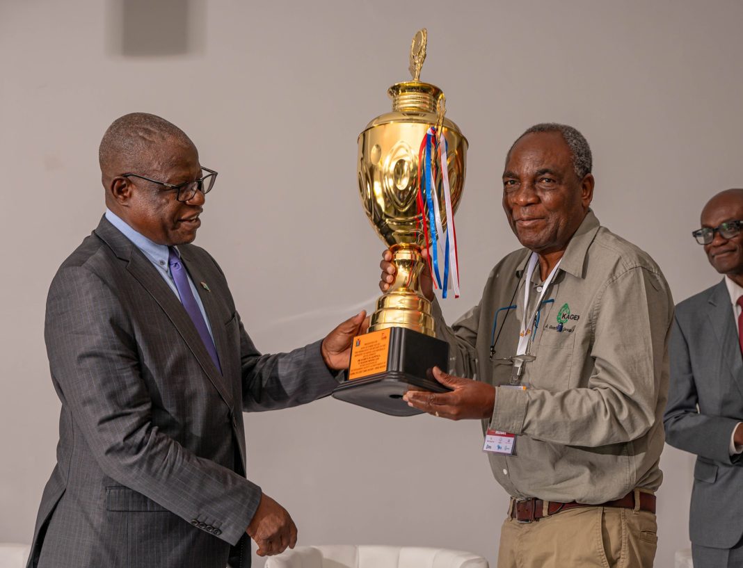 Permanent Secretary at the Ministry of Mines and Minerals Development, Dr Hapenga M. Kabeta, handing the trophy to the Chairman of the Board at Kagem, Dr Sixtus Mulenga