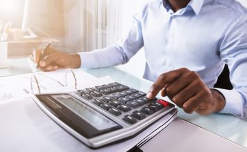 Beyond box ticking: ‘local content’ in Zambian mining Close-up Of A Businessman Calculating Invoice Using Calculator At Workplace