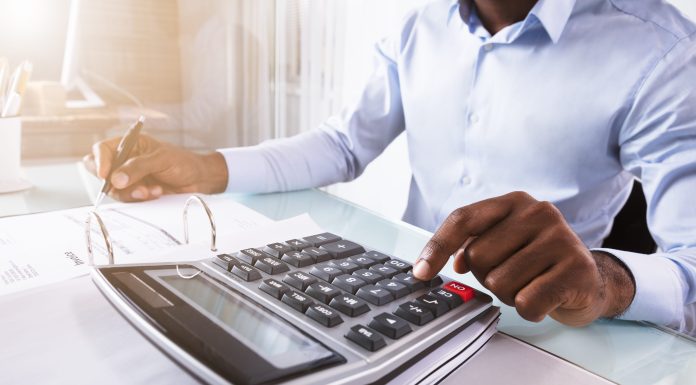 Beyond box ticking: ‘local content’ in Zambian mining Close-up Of A Businessman Calculating Invoice Using Calculator At Workplace